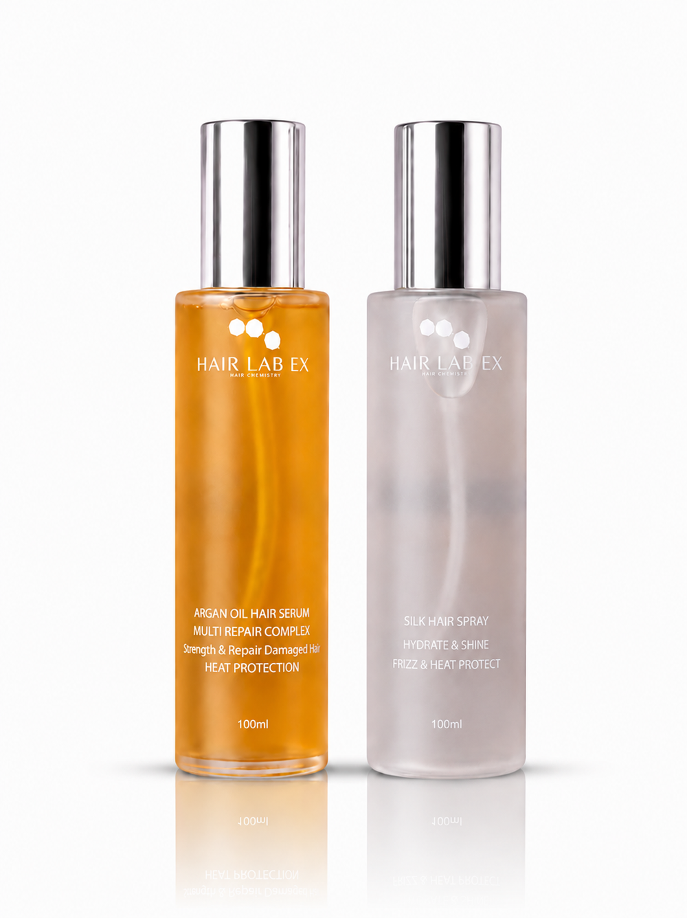 Two Hair Lab Ex hair care bottles on a white background: an amber oil hair serum on the left and a milky hair spray on the right, both with silver caps.